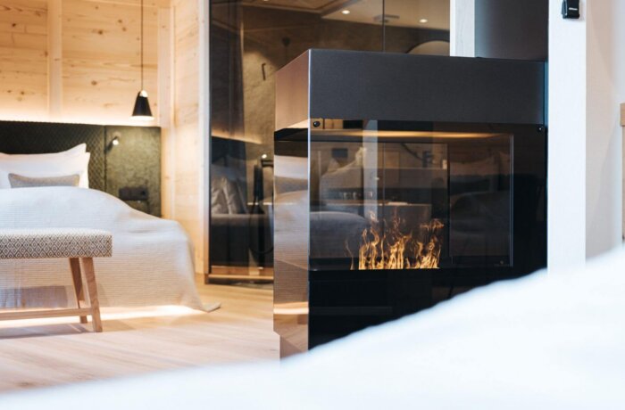 Elegant designsuite med pejs, varme naturmaterialer og moderne alpint design på Hotel Schneider i Obertauern