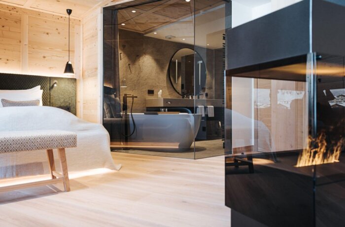 Elegant designsuite med fritstående badekar, pejs og varme naturmaterialer på Hotel Schneider i Obertauern