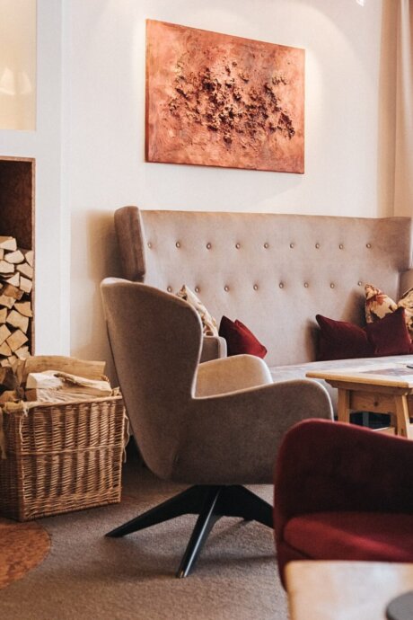 Hyggelig lounge med kunst, varme naturmaterialer og alpint design på Hotel Schneider i Obertauern