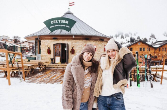 Gæster nyder vinterstemningen foran Der Turm, Hotel Schneiders egen après-ski bar i Obertauern