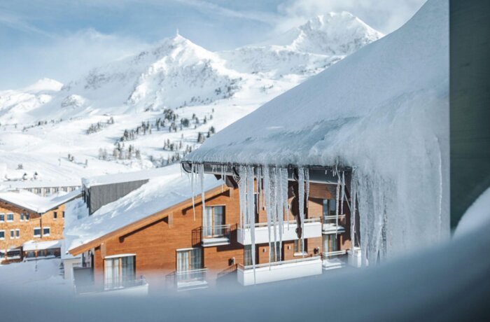 Hotel Schneider omgivet af sneklædte bjerge i Obertauern – et af Østrigs mest snesikre skiområder