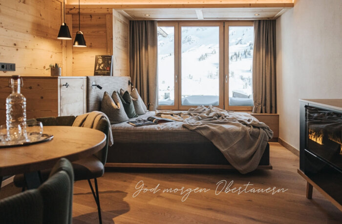 Elegant designsuite med pejs, naturlige materialer og bjergudsigt på Hotel Schneider i Obertauern
